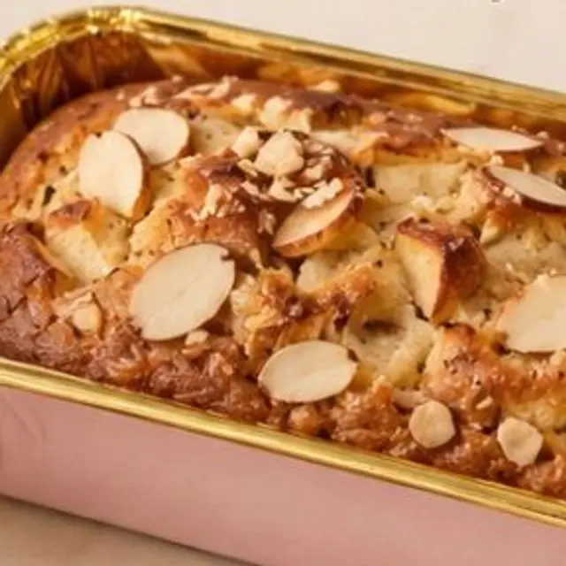An apple and almond loaf cake in a pink baking tin