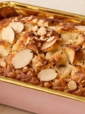 An apple and almond loaf in a pink tin